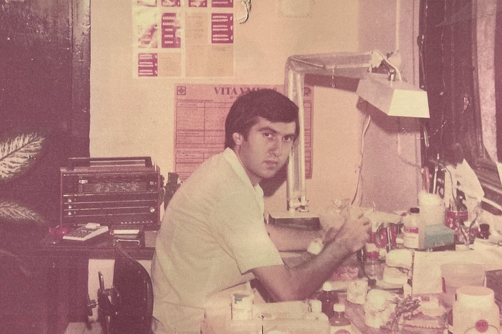 Vintage photograph of a young Boris Abayev at his lab bench, surrounded by instruments and materials