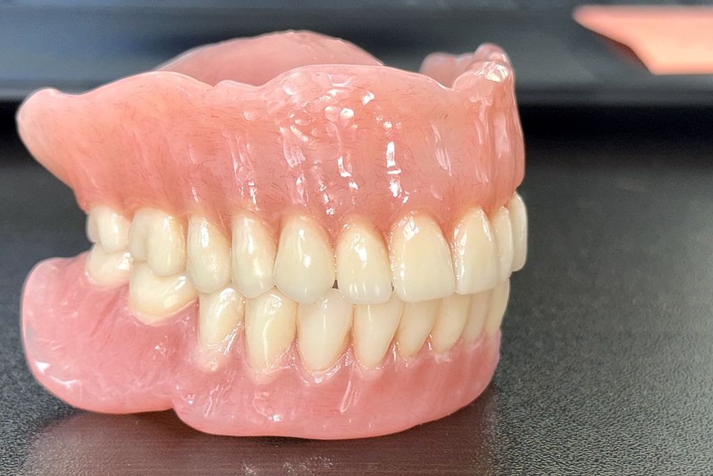 Complete upper and lower dentures with pink acrylic bases