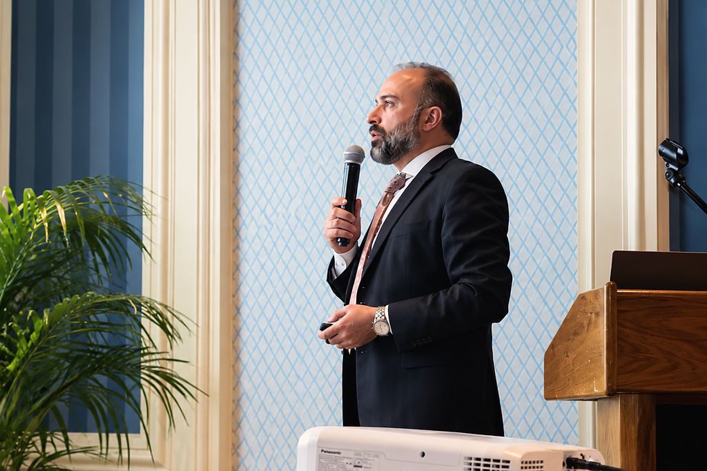 David Abayev presenting with a microphone at the Dental Study Club of New York