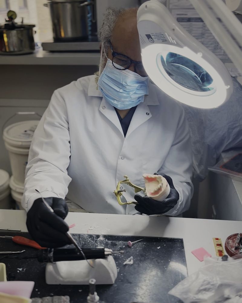 A ceramist working on an all-ceramic restoration at the bench