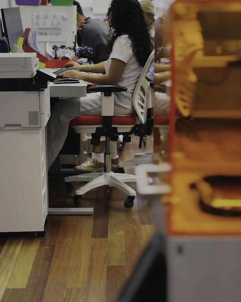 Inside the lab: workstations along the window with a team member at a desk
